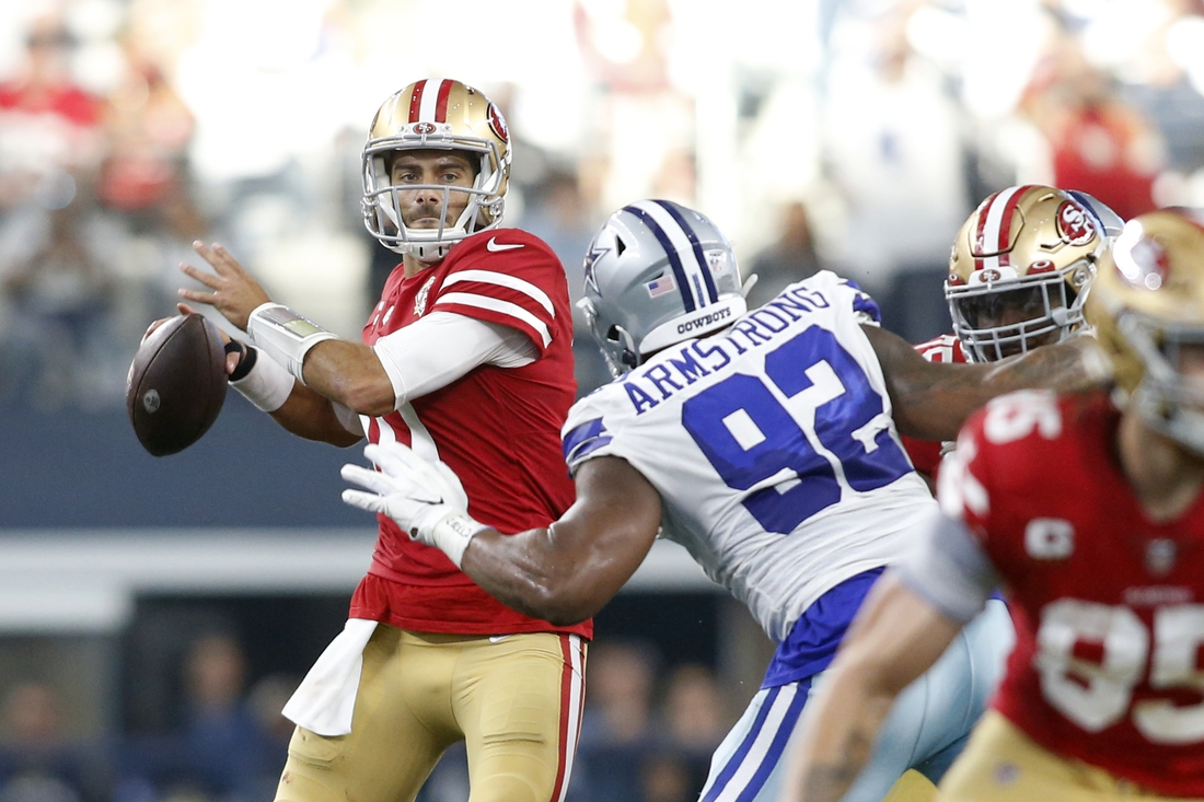 Jan 16, 2022; Arlington, Texas, USA; San Francisco 49ers quarterback Jimmy Garoppolo (10) throws the ball against Dallas Cowboys defensive end Dorance Armstrong (92) in the second quarter in a NFC Wild Card playoff football game at AT&T Stadium. Mandatory Credit: Tim Heitman-USA TODAY Sports