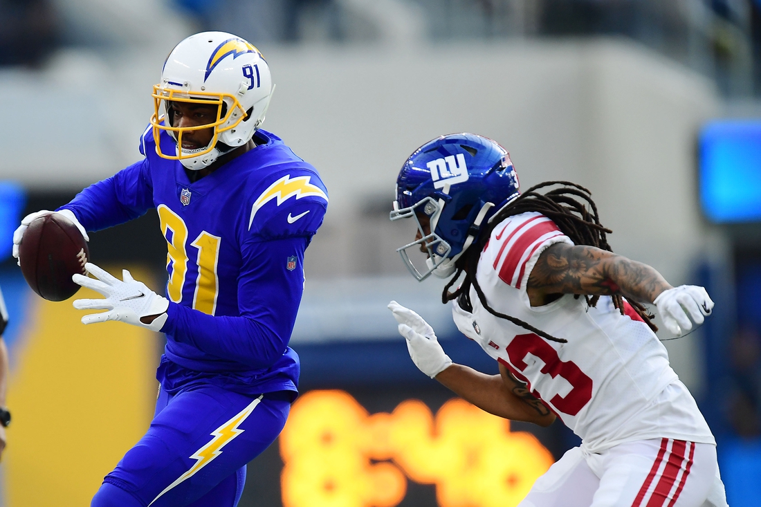 Dec 12, 2021; Inglewood, California, USA; Los Angeles Chargers wide receiver Mike Williams (81) runs the ball ahead of New York Giants safety Logan Ryan (23) during the first half at SoFi Stadium. Mandatory Credit: Gary A. Vasquez-USA TODAY Sports
