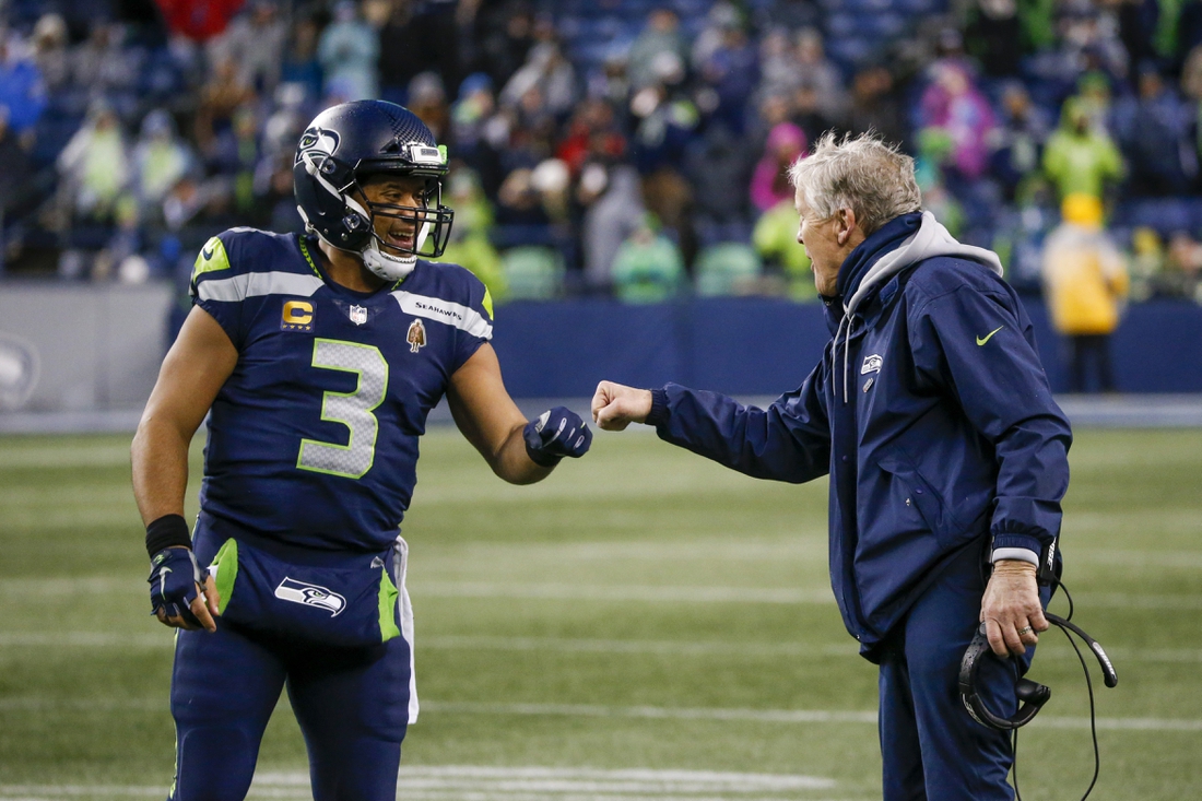Jan 2, 2022; Seattle, Washington, USA; Seattle Seahawks quarterback Russell Wilson (3) bumps fists with head coach Pete Carroll during the fourth quarter two-minute warning against the Detroit Lions at Lumen Field. Mandatory Credit: Joe Nicholson-USA TODAY Sports