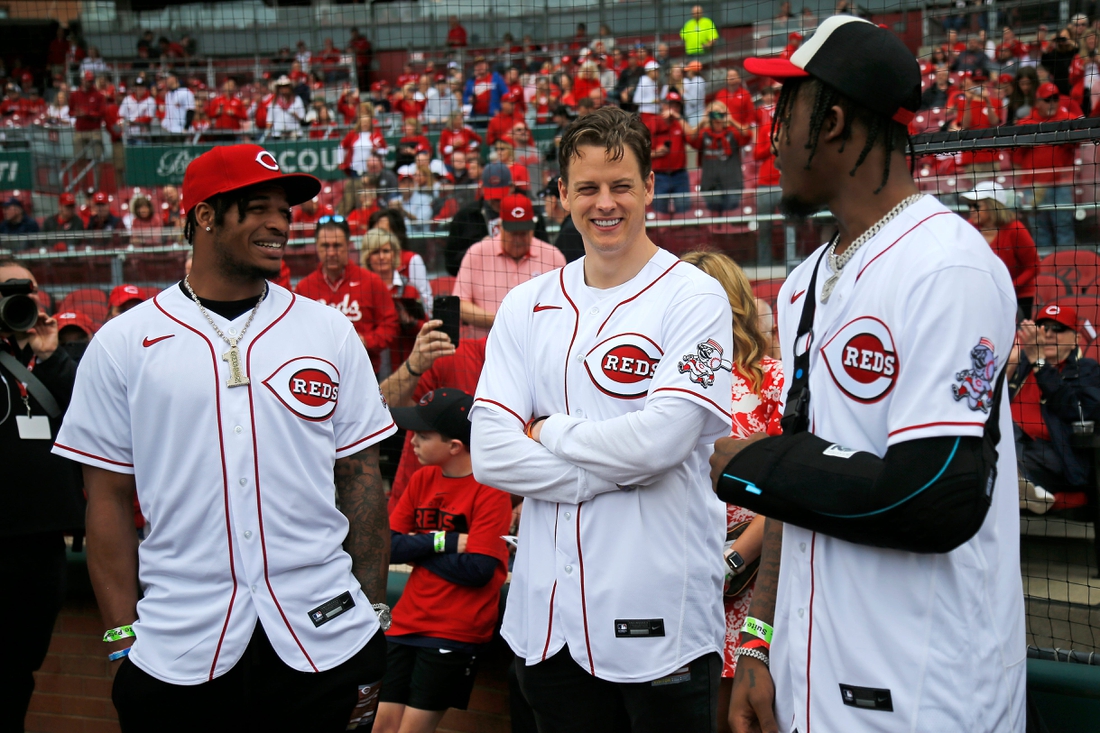 Cincinnati Bengals quarterback Joe Burrow (center) talks with wide receivers Ja'Marr Chase (left) Tee Higgins (right) before the Reds home opening game between the Cincinnati Reds and the Cleveland Guardians at Great American Ball Park in downtown Cincinnati on Tuesday, April 12, 2022.

Cleveland Guardians At Cincinnati Reds Home Opener