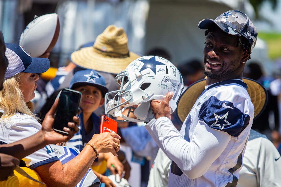 Aug 2, 2022; Oxnard, CA, USA; Dallas Cowboys wide receiver Michael Gallup (13) signs autographs during training camp at River Ridge Playing Fields in Oxnard, California. Mandatory Credit: Jason Parkhurst-USA TODAY Sports