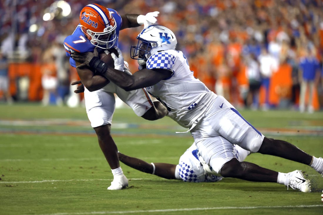 Sep 10, 2022; Gainesville, Florida, USA; Florida Gators running back Trevor Etienne (7) runs with the ball as Kentucky Wildcats defensive tackle Octavious Oxendine (8) tackles  during the first half at Ben Hill Griffin Stadium. Mandatory Credit: Kim Klement-USA TODAY Sports
