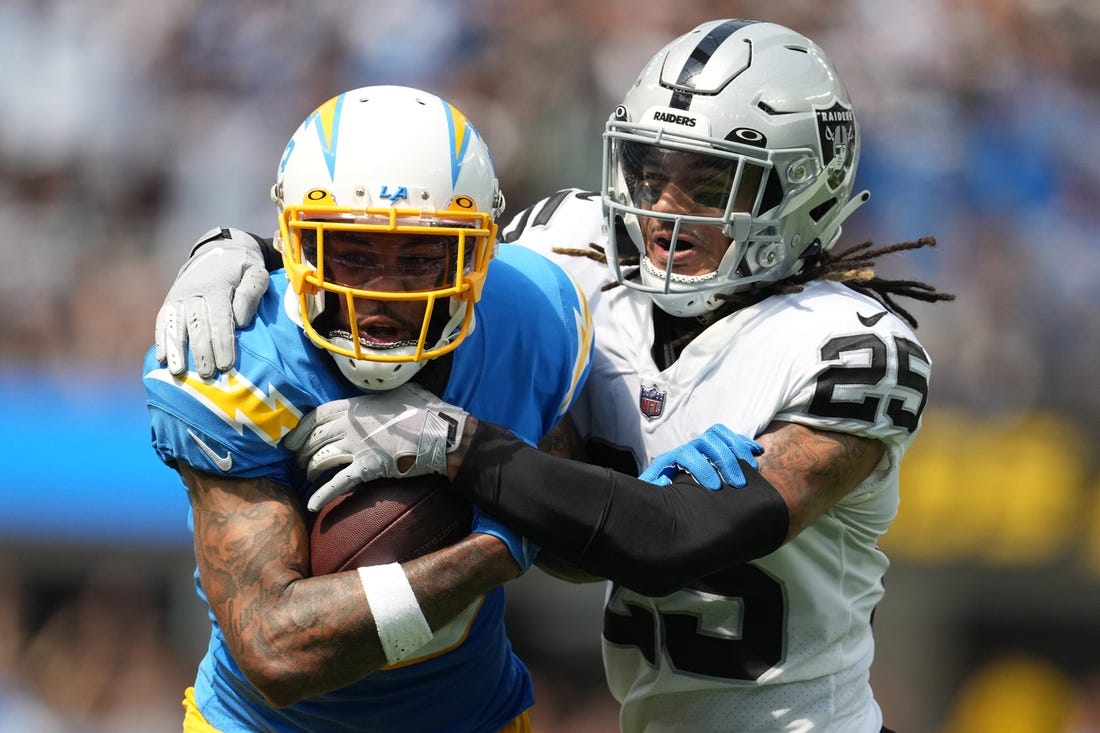 Sep 11, 2022; Inglewood, California, USA; Los Angeles Chargers wide receiver Keenan Allen (13) tries to break free from the grasp of Las Vegas Raiders safety Tre'von Moehrig (25) in the first half at SoFi Stadium. Mandatory Credit: Kirby Lee-USA TODAY Sports