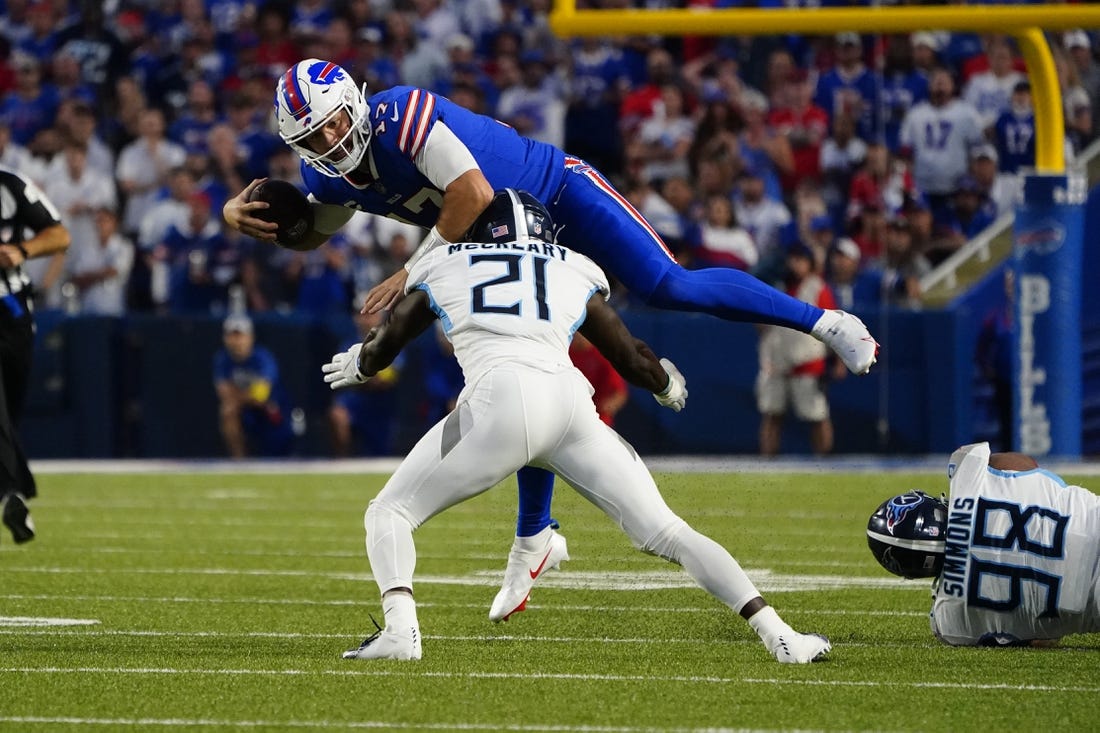 Sep 19, 2022; Orchard Park, New York, USA; Buffalo Bills quarterback Josh Allen (17) leaps over Tennesse Titans cornerback Roger McCreary (21) running with the ball during the first half at Highmark Stadium. Mandatory Credit: Gregory Fisher-USA TODAY Sports