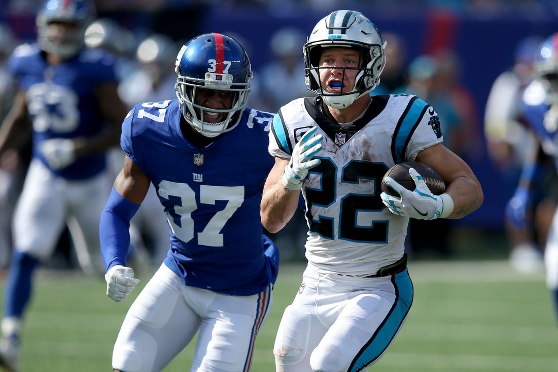 Sep 18, 2022; East Rutherford, New Jersey, USA; Carolina Panthers running back Christian McCaffrey (22) runs with the ball against New York Giants defensive back Fabian Moreau (37) during the fourth quarter at MetLife Stadium. Mandatory Credit: Brad Penner-USA TODAY Sports