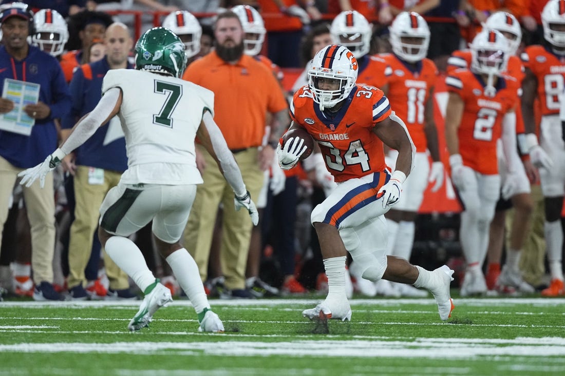 Oct 1, 2022; Syracuse, New York, USA; Syracuse Orange running back Sean Tucker (34) runs with the ball with Wagner Seahawks defensive back Coby Calvin (7) defending during the first half at JMA Wireless Dome. Mandatory Credit: Gregory Fisher-USA TODAY Sports