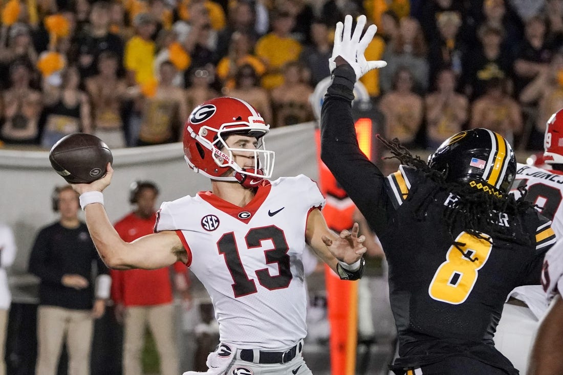 Oct 1, 2022; Columbia, Missouri, USA; Georgia Bulldogs quarterback Stetson Bennett (13) throws a pass as Missouri Tigers linebacker Ty'Ron Hopper (8) tries to block during the second half at Faurot Field at Memorial Stadium. Mandatory Credit: Denny Medley-USA TODAY Sports