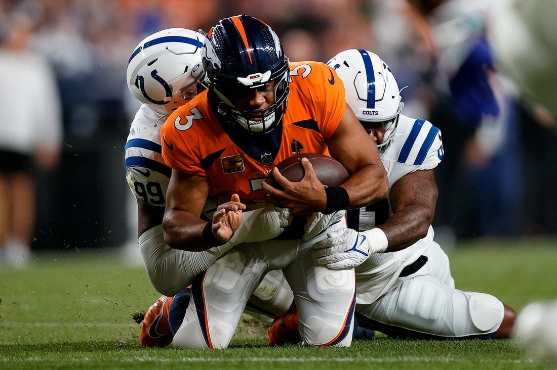Oct 6, 2022; Denver, Colorado, USA; Denver Broncos quarterback Russell Wilson (3) is tackled by Indianapolis Colts defensive tackle DeForest Buckner (99) and defensive end Yannick Ngakoue (91) in the third quarter at Empower Field at Mile High. Mandatory Credit: Isaiah J. Downing-USA TODAY Sports