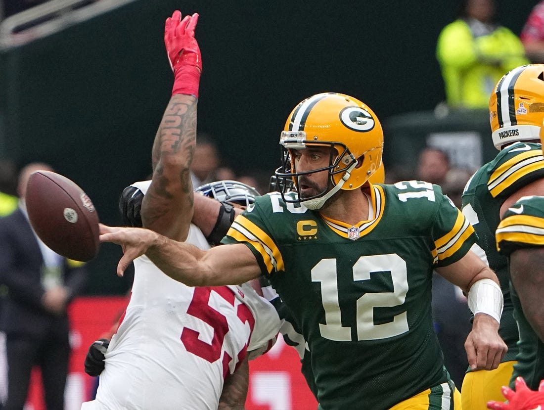 Oct 9, 2022; Tottenham, ENG;  Green Bay Packers quarterback Aaron Rodgers (12) flips the ball to tight end Robert Tonyan during the second quarter of their game against the New York Giants at Tottenham Hotspur Stadium. Mandatory Credit: Mark Hoffman-USA TODAY Sports