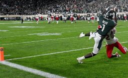 Oct 15, 2022; East Lansing, Michigan, USA;  Michigan State Spartans wide receiver Jayden Reed (1) catches a touchdown pass in spite of Wisconsin Badgers cornerback Ricardo Hallman (2) in a second overtime period to win the game, 34-28, at Spartan Stadium. Mandatory Credit: Dale Young-USA TODAY Sports