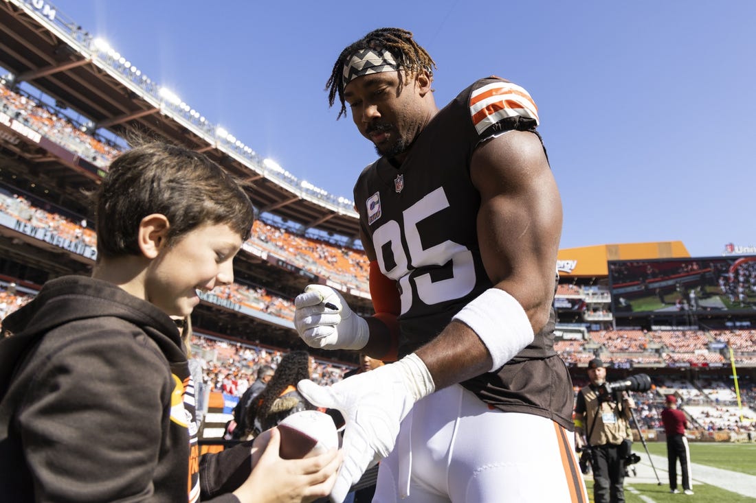 Oct 16, 2022; Cleveland, Ohio, USA; Cleveland Browns defensive end Myles Garrett (95) autographs a souvenir for a fan before the game against the New England Patriots at FirstEnergy Stadium. Mandatory Credit: Scott Galvin-USA TODAY Sports