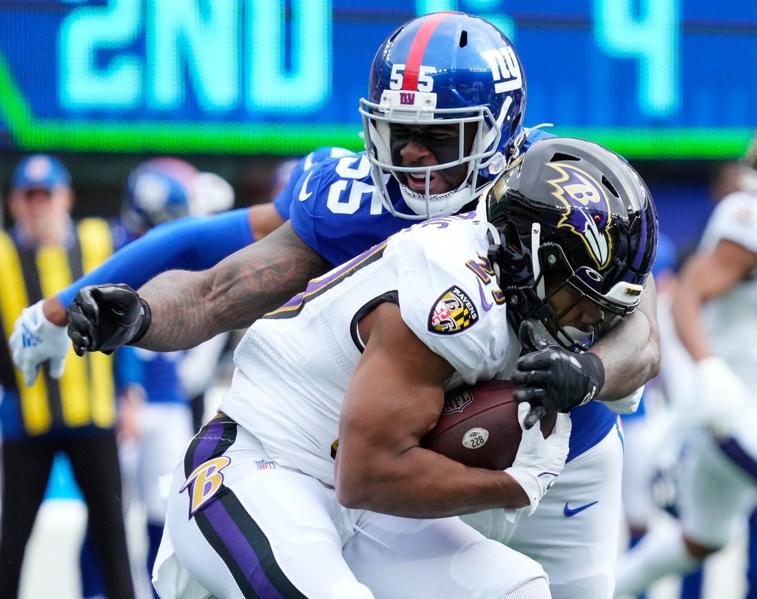 Oct 16, 2022; East Rutherford, New Jersey, USA; Baltimore Ravens running back J.K. Dobbins (27) is tackled by New York Giants linebacker Jihad Ward (55) during the first quarter at MetLife Stadium. Mandatory Credit: Robert Deutsch-USA TODAY Sports