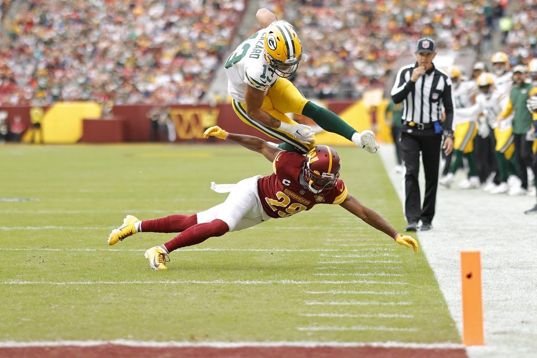Oct 23, 2022; Landover, Maryland, USA; Green Bay Packers wide receiver Allen Lazard (13) leaps over Washington Commanders cornerback Kendall Fuller (29) while attempting to score a touchdown during the first quarter at FedExField. Mandatory Credit: Geoff Burke-USA TODAY Sports