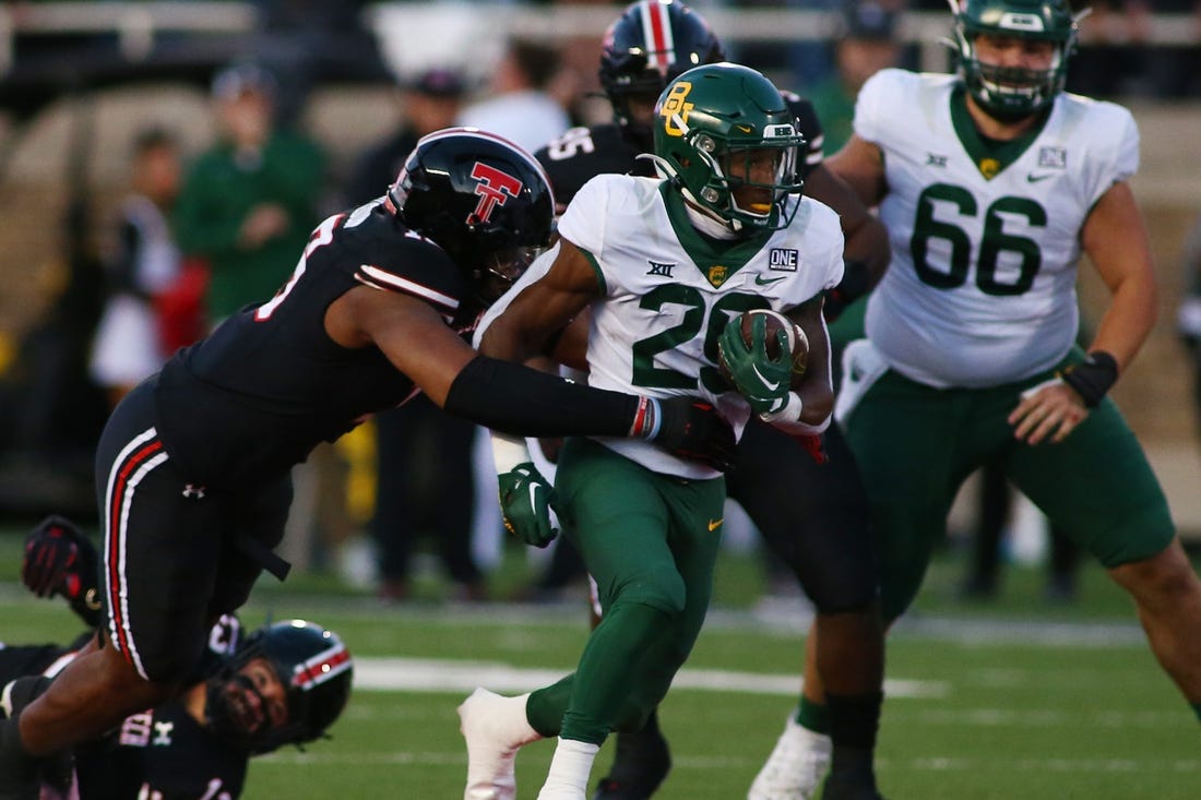 Oct 29, 2022; Lubbock, Texas, USA;  Baylor Bears running back Richard Reese (29) rushes against Texas Tech Red Raiders defensive linebacker Tyree Wilson (19) in the first half at Jones AT&T Stadium and Cody Campbell Field. Mandatory Credit: Michael C. Johnson-USA TODAY Sports