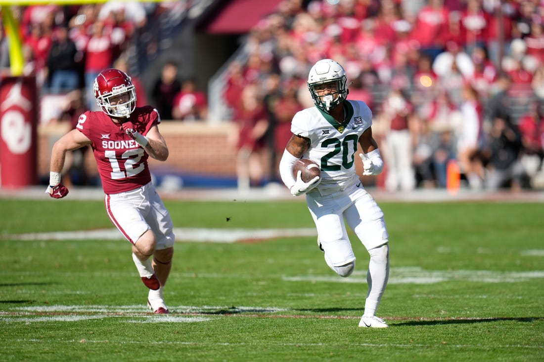 Nov 5, 2022; Norman, Oklahoma, USA; Baylor Bears safety Devin Lemear (20) returns an interception as Oklahoma Sooners wide receiver Drake Stoops (12) chases during the first half at Gaylord Family-Oklahoma Memorial Stadium. Mandatory Credit: Chris Jones-USA TODAY Sports