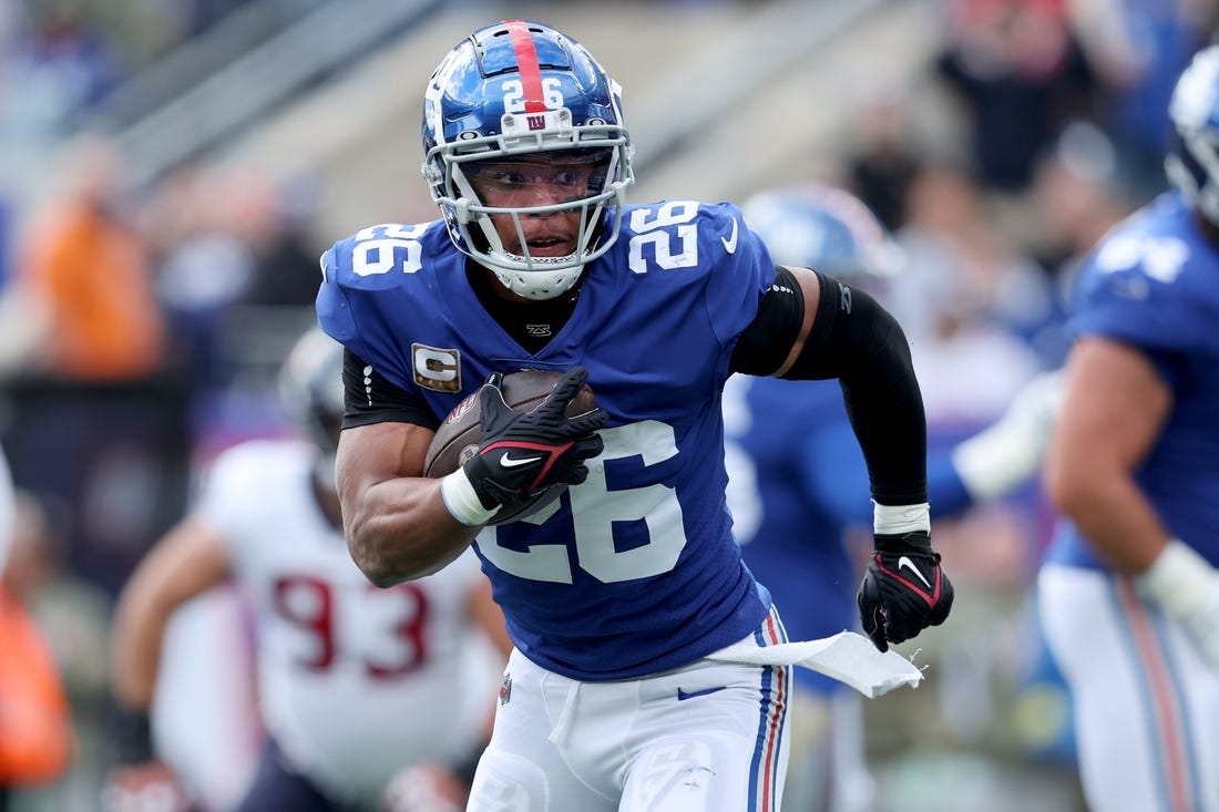 Nov 13, 2022; East Rutherford, New Jersey, USA; New York Giants running back Saquon Barkley (26) runs with the ball against the Houston Texans during the first quarter at MetLife Stadium. Mandatory Credit: Brad Penner-USA TODAY Sports