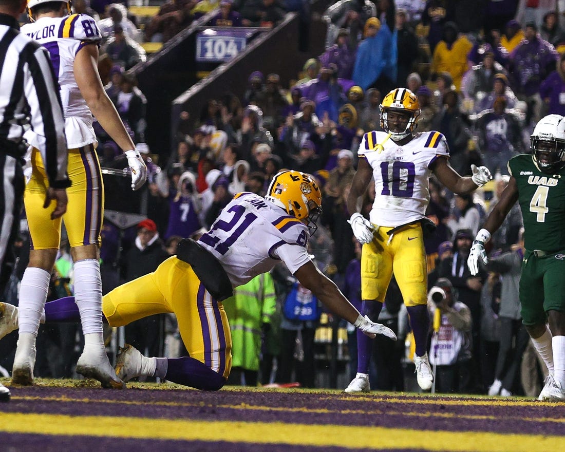Nov 19, 2022; Baton Rouge, Louisiana, USA;  LSU Tigers quarterback Tavion Faulk (12) falls into the end zone for a touchdown against the UAB Blazers during the first half at Tiger Stadium. Mandatory Credit: Stephen Lew-USA TODAY Sports