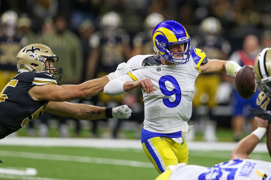 Nov 20, 2022; New Orleans, Louisiana, USA; Los Angeles Rams quarterback Matthew Stafford (9) is grabbed by New Orleans Saints linebacker Kaden Elliss (55) in the second quarter at the Caesars Superdome. Mandatory Credit: Chuck Cook-USA TODAY Sports