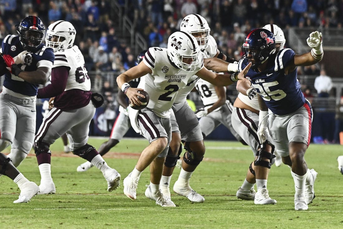 Nov 24, 2022; Oxford, Mississippi, USA; Mississippi State Bulldogs quarterback Will Rogers (2) moves in the pocket while defended by Ole Miss Rebels defensive end Tavius Robinson (95) during the first quarter at Vaught-Hemingway Stadium. Mandatory Credit: Matt Bush-USA TODAY Sports