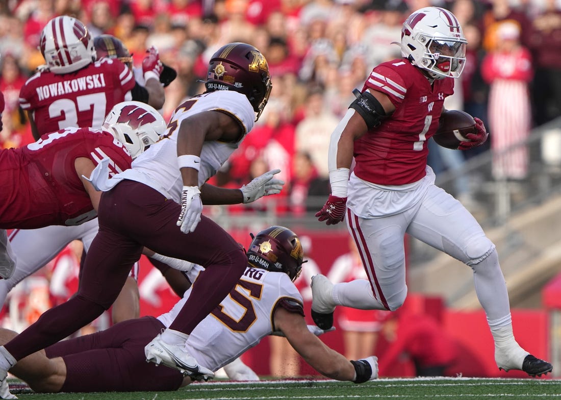 Nov 26, 2022; Madison, Wisconsin, USA; Wisconsin running back Chez Mellusi (1) runs for a first down during the first quarter of their game against Minnesota  at Camp Randall Stadium. Mandatory Credit: Mark Hoffman-USA TODAY Sports