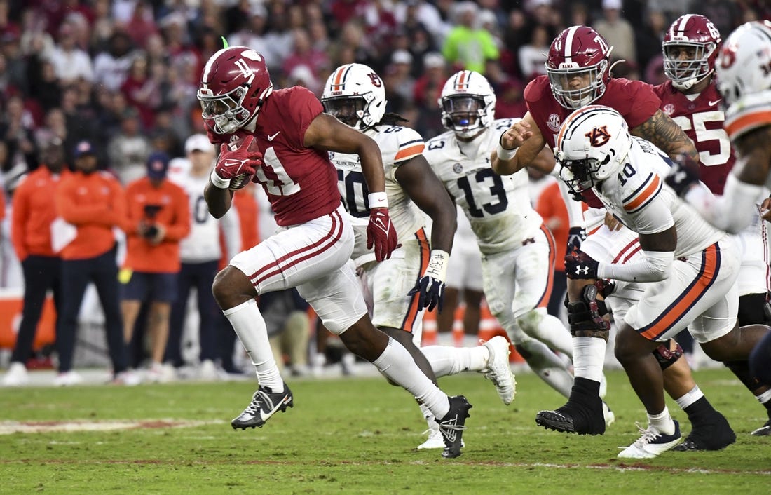 Nov 26, 2022; Tuscaloosa, Alabama, USA; Alabama wide receiver Traeshon Holden (11) breaks away from Auburn defenders including Auburn safety Zion Puckett (10) and Auburn defensive lineman Marcus Harris (50) on his way to a touchdown at Bryant-Denny Stadium. Mandatory Credit: Gary Cosby Jr.-USA TODAY Sports