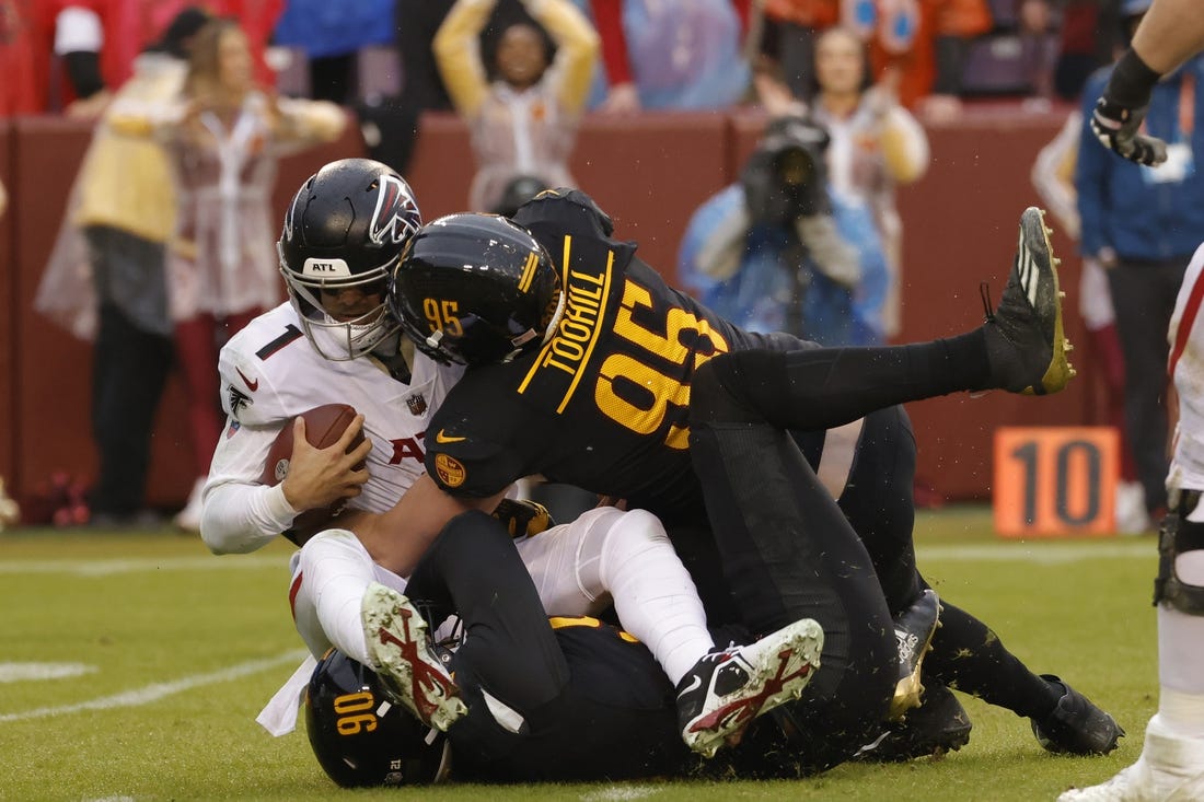 Nov 27, 2022; Landover, Maryland, USA; Atlanta Falcons quarterback Marcus Mariota (1) is sacked by Washington Commanders defensive end Montez Sweat (90) and Commanders defensive end James Smith-Williams (96) during the fourth quarter at FedExField. Mandatory Credit: Geoff Burke-USA TODAY Sports