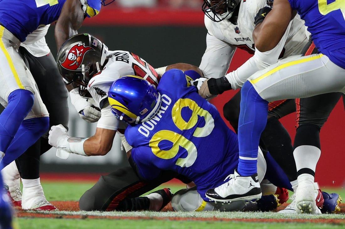 Nov 6, 2022; Tampa, Florida, USA;  Tampa Bay Buccaneers quarterback Tom Brady (12) is sacked by Los Angeles Rams defensive tackle Aaron Donald (99) in the third quarter at Raymond James Stadium. Mandatory Credit: Nathan Ray Seebeck-USA TODAY Sports