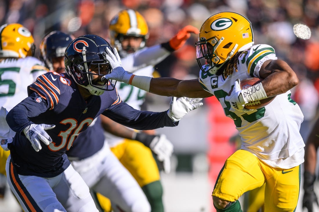 Dec 4, 2022; Chicago, Illinois, USA; Green Bay Packers running back Aaron Jones (33) runs the ball as Chicago Bears defensive back DeAndre Houston-Carson (36) pursues on defense in the first quarter at Soldier Field. Mandatory Credit: Daniel Bartel-USA TODAY Sports
