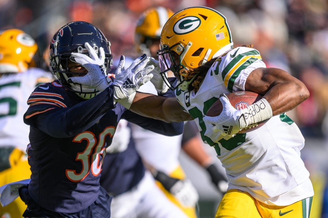 Dec 4, 2022; Chicago, Illinois, USA; Green Bay Packers running back Aaron Jones (33) runs the ball as Chicago Bears defensive back DeAndre Houston-Carson (36) pursues on defense in the first quarter at Soldier Field. Mandatory Credit: Daniel Bartel-USA TODAY Sports