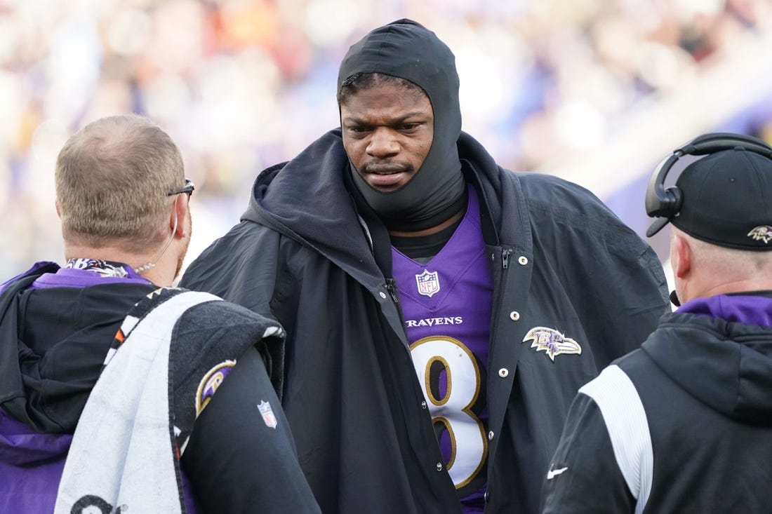 Dec 4, 2022; Baltimore, Maryland, USA; Baltimore Ravens quarterback Lamar Jackson (8) talks with team staff on the sideline in the second quarter after being sacked against the Denver Broncos at M&T Bank Stadium. Mandatory Credit: Mitch Stringer-USA TODAY Sports