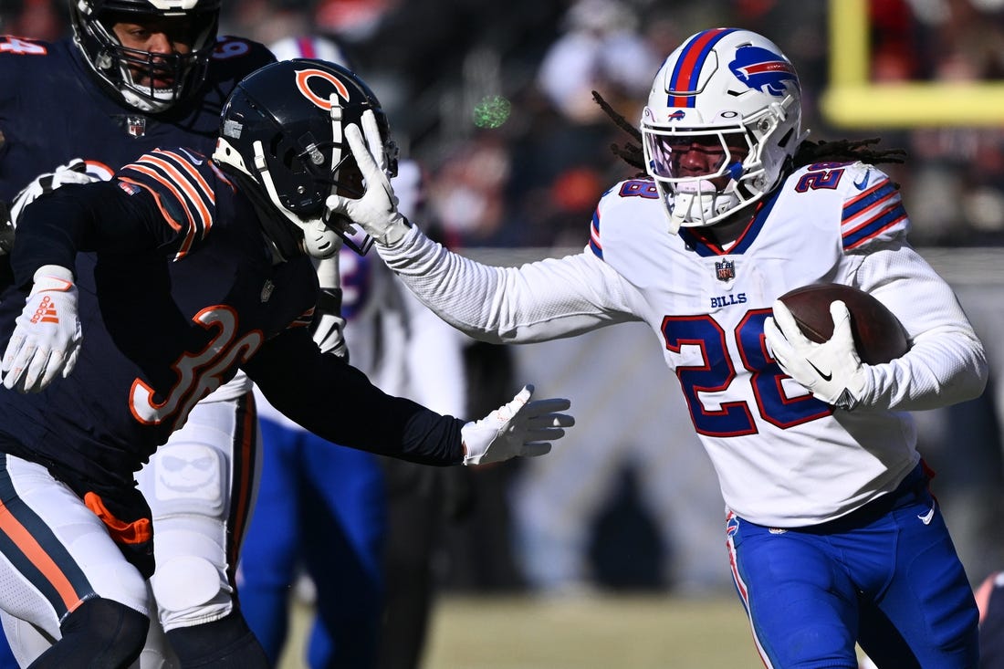 Dec 24, 2022; Chicago, Illinois, USA;  Buffalo Bills running back James Cook (28) fends off tackler Chicago Bears defensive back DeAndre Houston-Carson (36) in the first half at Soldier Field. Mandatory Credit: Jamie Sabau-USA TODAY Sports
