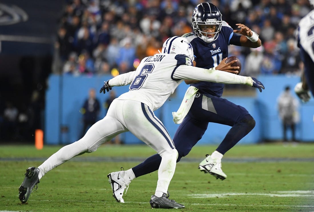 Dec 29, 2022; Nashville, Tennessee, USA; Tennessee Titans quarterback Joshua Dobbs (11) is tackled for a loss by Dallas Cowboys safety Donovan Wilson (6) during the first half at Nissan Stadium. Mandatory Credit: Christopher Hanewinckel-USA TODAY Sports