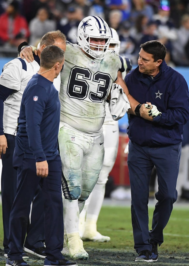 Dec 29, 2022; Nashville, Tennessee, USA; Dallas Cowboys center Tyler Biadasz (63) is helped off the field after an injury during the second half against the Tennessee Titans at Nissan Stadium. Mandatory Credit: Christopher Hanewinckel-USA TODAY Sports