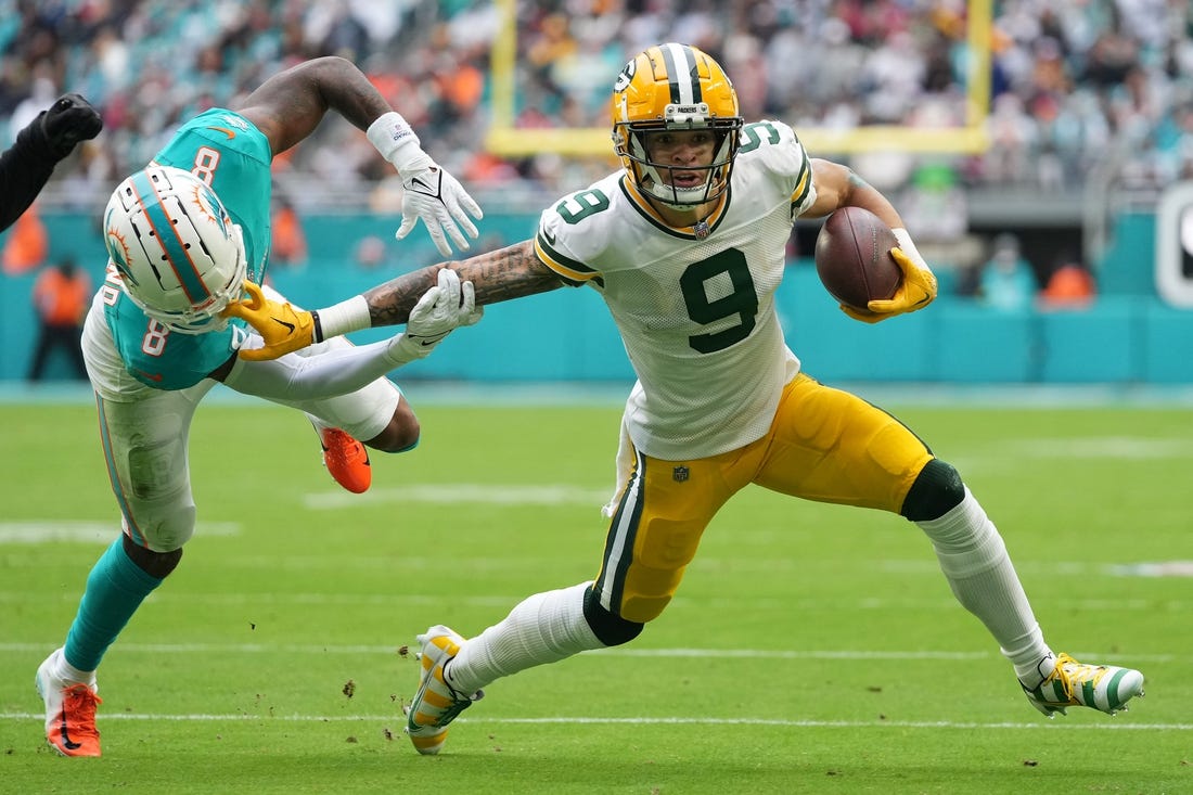 Dec 25, 2022; Miami Gardens, Florida, USA; Miami Dolphins safety Jevon Holland (8) attempts to tackle Green Bay Packers wide receiver Christian Watson (9) during the first half at Hard Rock Stadium. Mandatory Credit: Jasen Vinlove-USA TODAY Sports