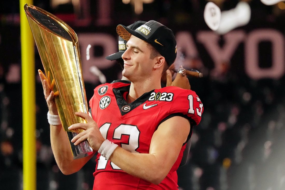 Jan 9, 2023; Inglewood, CA, USA; Georgia Bulldogs quarterback Stetson Bennett (13) holds the trophy after winning the CFP national championship game against the TCU Horned Frogs at SoFi Stadium. Mandatory Credit: Kirby Lee-USA TODAY Sports