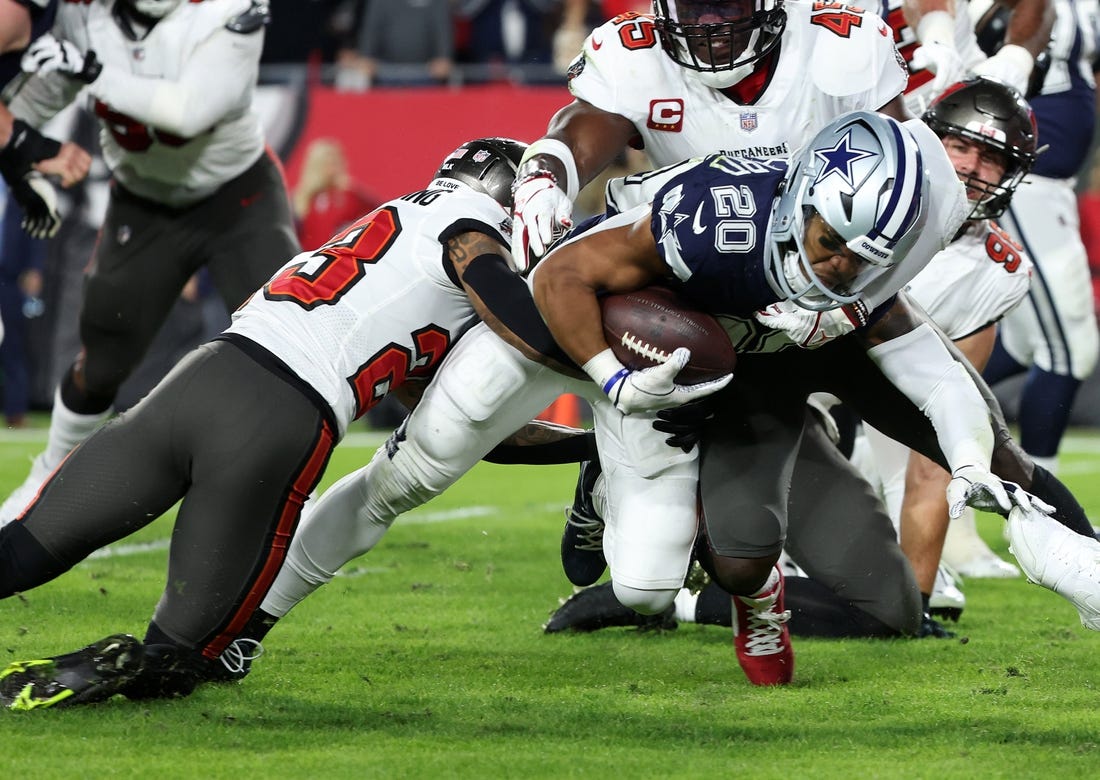 Jan 16, 2023; Tampa, Florida, USA; Dallas Cowboys running back Tony Pollard (20) rushes the ball against Tampa Bay Buccaneers safety Mike Edwards (32) in the first half during the wild card game at Raymond James Stadium. Mandatory Credit: Kim Klement-USA TODAY Sports