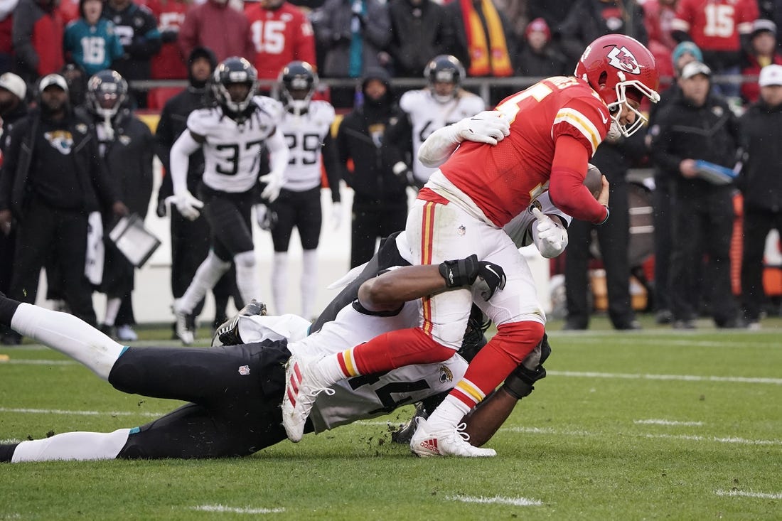 Jan 21, 2023; Kansas City, Missouri, USA; Kansas City Chiefs quarterback Patrick Mahomes (15) is brought down by Jacksonville Jaguars linebacker Travon Walker (44) during the first half in the AFC divisional round game at GEHA Field at Arrowhead Stadium. Mandatory Credit: Denny Medley-USA TODAY Sports