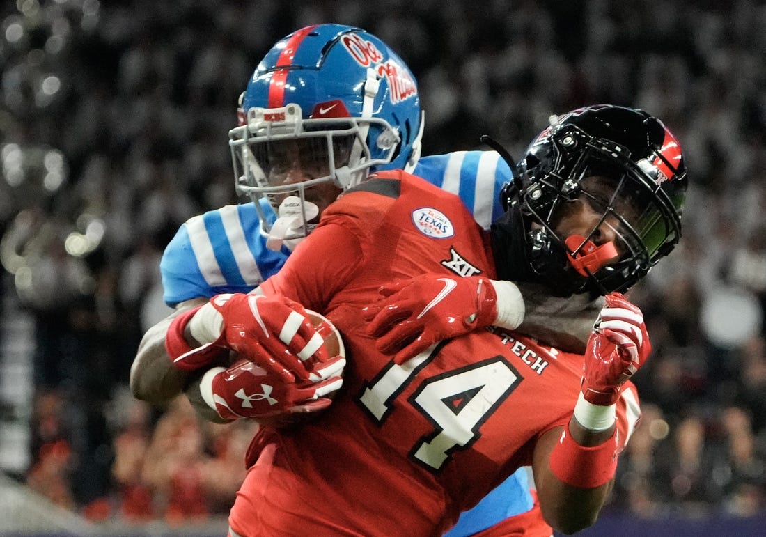 Dec 28, 2022; Houston, Texas, USA;  Texas Tech Red Raiders wide receiver Xavier White (14) is tackled by Mississippi Rebels cornerback Davison Igbinosun (20) in the second half in the 2022 Texas Bowl at NRG Stadium. Mandatory Credit: Thomas Shea-USA TODAY Sports