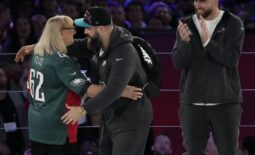 Feb 6, 2023; Phoenix, AZ, USA;  Donna Kelce hugs her son Philadelphia Eagles center Jason Kelce (62) while her other son Kansas City Chiefs tight end Travis Kelce (87) claps during Super Bowl Opening Night at Footprint Center. Mandatory Credit: Cheryl Evans-USA TODAY Sports