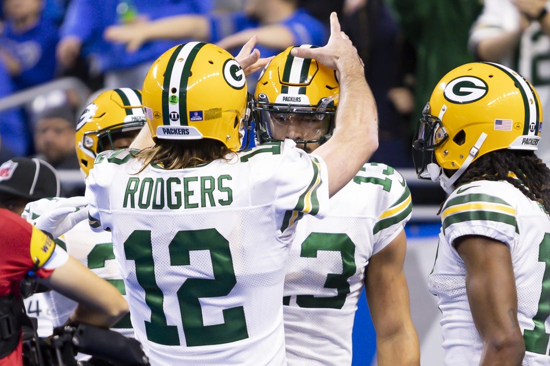 Jan 9, 2022; Detroit, Michigan, USA; Green Bay Packers quarterback Aaron Rodgers (12) celebrates with wide receiver Allen Lazard (13) after the pair connect for a touchdown during the first quarter against the Detroit Lions at Ford Field. Mandatory Credit: Raj Mehta-USA TODAY Sports