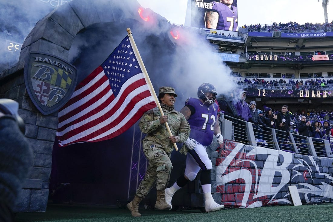 Nov 20, 2022; Baltimore, Maryland, USA;  Baltimore Ravens guard Ben Powers (72) takes the field with a member of the U.S. military for introductions before the game against the Carolina Panthers at M&T Bank Stadium. Mandatory Credit: Jessica Rapfogel-USA TODAY Sports