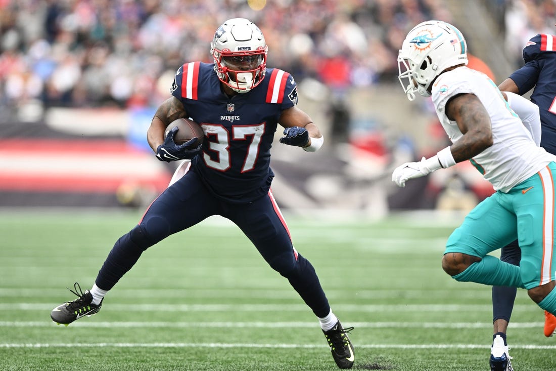 Jan 1, 2023; Foxborough, Massachusetts, USA; New England Patriots running back Damien Harris (37) rushes against Miami Dolphins safety Jevon Holland (8) during the first half at Gillette Stadium. Mandatory Credit: Brian Fluharty-USA TODAY Sports