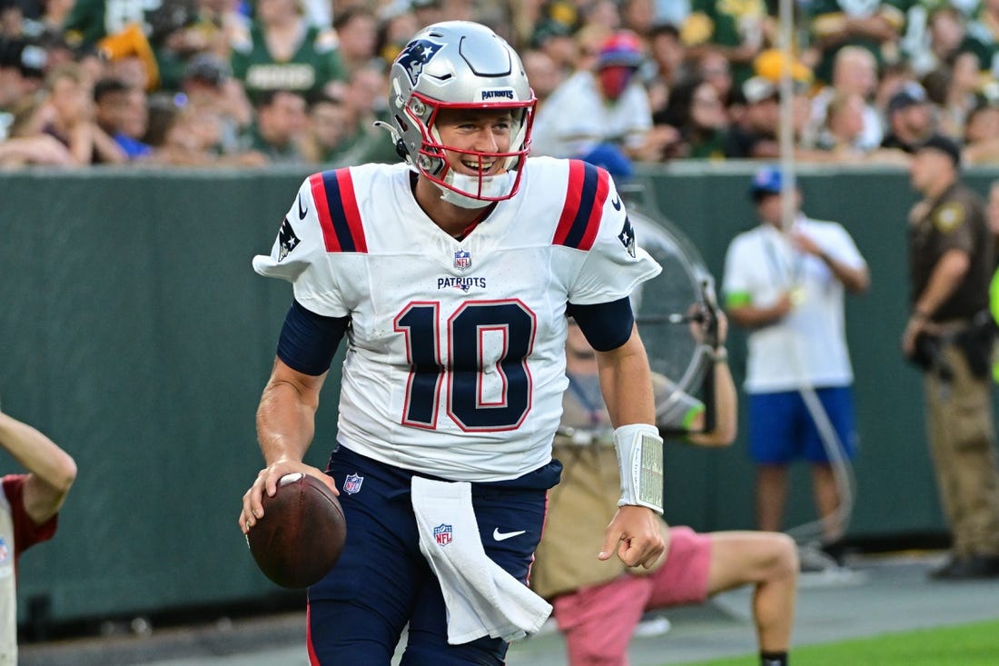 Aug 19, 2023; Green Bay, Wisconsin, USA; New England Patriots quarterback Mac Jones (10) reacts after the Patriots scored a touchdown against the Green Bay Packers at Lambeau Field. Mandatory Credit: Benny Sieu-USA TODAY Sports