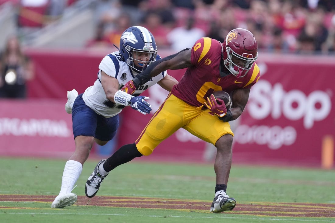 Sep 2, 2023; Los Angeles, California, USA; Southern California Trojans running back MarShawn Lloyd (0) carries the ball against Nevada Wolf Pack defensive back Ezekiel Robbins (13) in the first half at United Airlines Field at Los Angeles Memorial Coliseum. Mandatory Credit: Kirby Lee-USA TODAY Sports