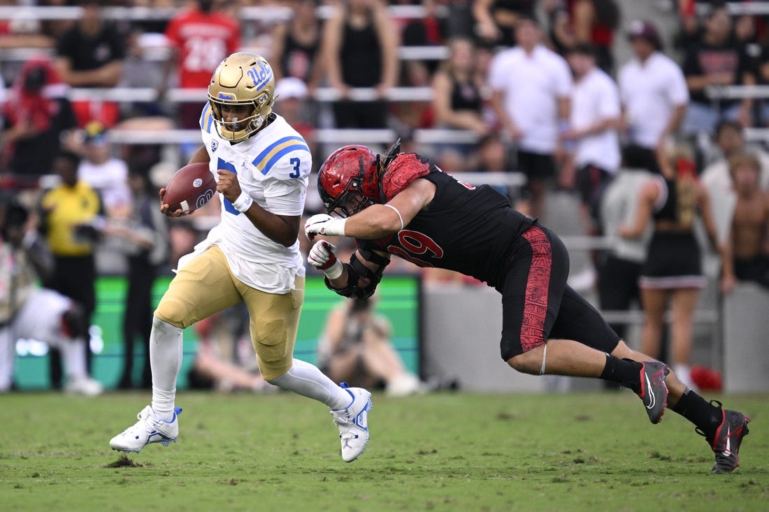 Sep 9, 2023; San Diego, California, USA; UCLA Bruins quarterback Dante Moore (3) runs the ball while defended by San Diego State Aztecs defensive lineman Garret Fountain (39) during the first half at Snapdragon Stadium. Mandatory Credit: Orlando Ramirez-USA TODAY Sports