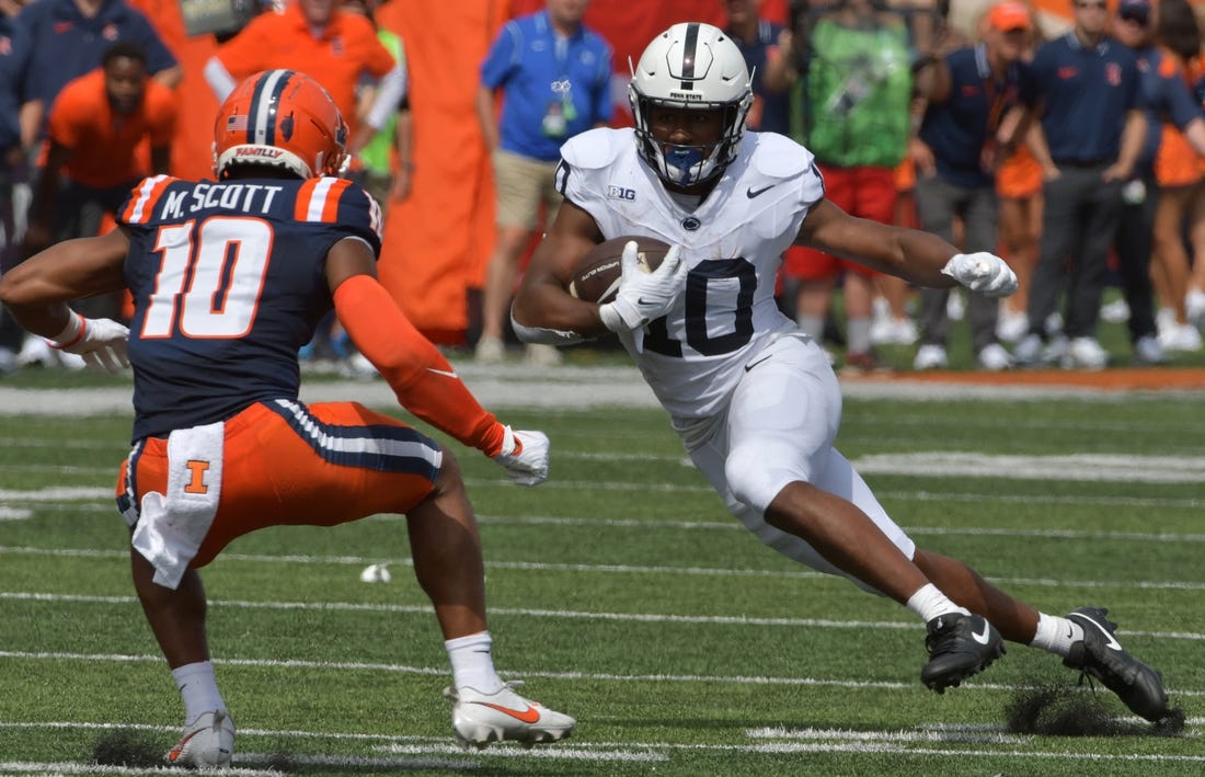 Sep 16, 2023; Champaign, Illinois, USA;  Penn State Nittany Lions running back Mehdi Flowers (right) runs the ball against Illinois Fighting Illini defensive back Miles Scott (10) during the first half at Memorial Stadium. Mandatory Credit: Ron Johnson-USA TODAY Sports
