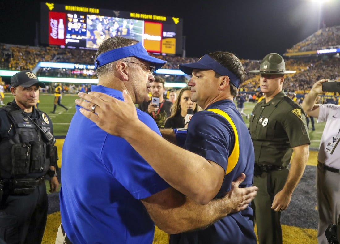 Sep 16, 2023; Morgantown, West Virginia, USA; West Virginia Mountaineers head coach Neal Brown speaks with Pittsburgh Panthers head coach Pat Narduzzi after the game at Mountaineer Field at Milan Puskar Stadium. Mandatory Credit: Ben Queen-USA TODAY Sports