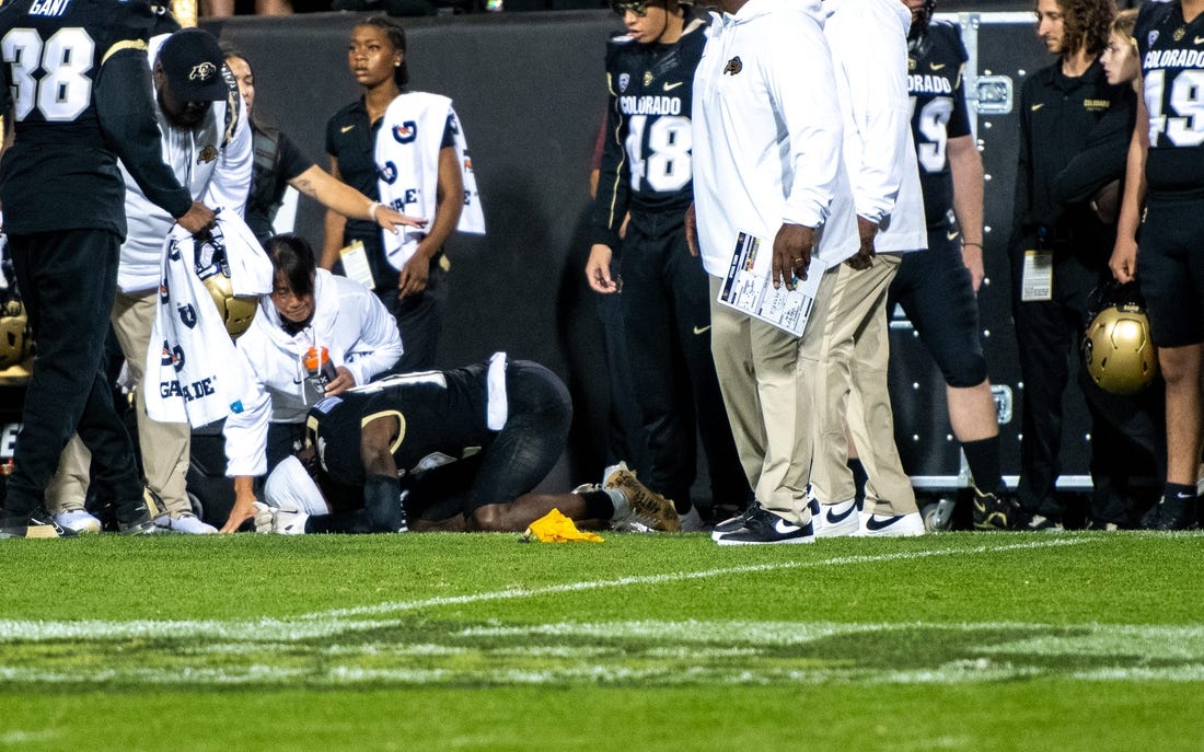 CU football's sophomore athlete Travis Hunter crumples in pain as a yellow penalty flag hits the ground following an illegal hit along the sideline by a CSU defender during the Rocky Mountain Showdown on Sept. 16, 2023 at Folsom Field in Boulder, Colo.