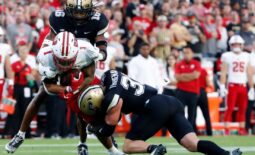 Wisconsin Badgers running back Chez Mellusi (1) is tackled by Purdue Boilermakers defensive back Marquis Wilson (16) and Purdue Boilermakers defensive back Dillon Thieneman (31) during the NCAA football game, Friday, Sept. 22, 2023, at Ross-Ade Stadium in West Lafayette, Ind.