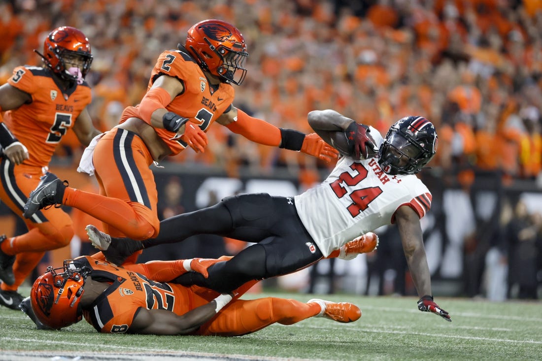 Sep 29, 2023; Corvallis, Oregon, USA; Utah Utes running back Chris Curry (24) is tackled by Oregon State Beavers defensive back Kitan Oladapo (28) during the first half at Reser Stadium. Mandatory Credit: Soobum Im-USA TODAY Sports